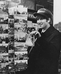 a young man standing next to a display of photos