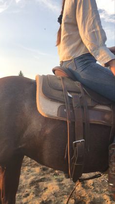 a woman riding on the back of a brown horse