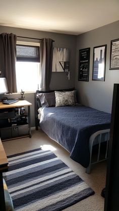 a bedroom with a bed, desk and pictures on the wall