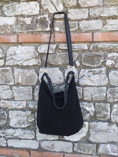 Handmade black suede hobo bag. This bag is unlined, inside there is a big cotton zipped pocket. The bag is closed with a zip The handle is an handmade leather braid. The sholder belt is removable and adjustable. This confortable hobo bag is very practical for any occasion. This bag is very large and soft and may contain many things. Features : - Black suede, - Unined, - Metal finishes are brass colored, - Closed with zip, - Inside zipped pocket, - Removable shoulder belt. Size : - Heigth 16 inch Suede Hobo Bag With Double Leather Handles, Black Leather Bag With Long Strap, Suede Hobo Bag With Adjustable Double Handle, Versatile Black Bucket Bag With Braided Handles, Black Leather Shoulder Bag With Braided Handles, Black Suede Bag With Detachable Strap, Black Suede Bags For Daily Use, Everyday Black Suede Shoulder Bag, Black Hobo Bag With Braided Handles For Daily Use