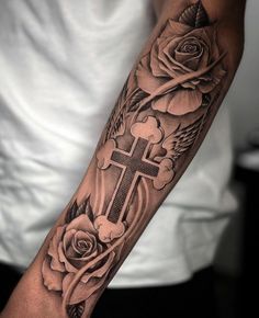 a man with a cross and roses tattoo on his arm