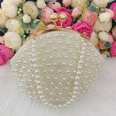 This luxurious encrusted pearl bridal clutch never fails to turn heads with its understated elegance and classic design. Adorned with varying sized White pearls and enhanced with a large creamy pearl clasp, this bridal clutch is the very picture of refinement. This elegant bridal clutch features rose gold trim, attachable chain and large enough for your phone. Complete your list of must-have wedding accessories with the ultimate bridal accessory to finish off your look and storing your wedding d Gold Clutch With Pearl Embroidery, Gold Pearl Clutch With Pearl Embroidery, Wedding Embellished Pearl Evening Bag, Formal Bridal Accessories In Pearl White, Cream Evening Bag With Pearl Embroidery For Party, Cream Pearl Evening Bag For Party, Beige Pearl Evening Bag For Events, Pearl White Pearl Evening Bag For Events, Cream Evening Bag With Pearl Embroidery For Wedding