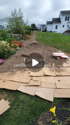 the yard is full of dirt and flowers, including an assortment of cardboard boxes that have been