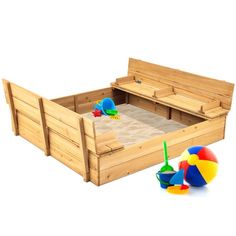 a wooden bed with sand and toys in it