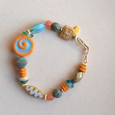 Summetime bohemian style bracelet made by miss.kvartz. This beautiful bracelet in orange and turquoise simply make you happy and remind you of a day at the sea. For this  bracelet I combined a mix of colorful high quality bohemian/czech glass beads. Czech glass beads are now produced was once known as Bohemia. Evidence of glass bead-making has been found in this area as far back as the 8th and 9th centuries, these glass beads are rare find Finished wiht a handmade gold filled hook clasp. Lovely Czech Beaded Bracelet, Multicolor Czech Glass Bohemian Bracelets, Bohemian Czech Glass Orange Beaded Bracelets, Eclectic Czech Glass Beaded Bracelets, Hand-strung Czech Glass Beaded Bracelets For Festivals, Czech Glass Bead Bracelet, Hand-strung Bohemian Czech Glass Stretch Bracelet, Czech Glass Jewelry, Glass Beaded Bracelet