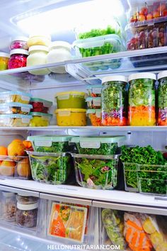 an open refrigerator filled with lots of different types of salads and fruit in plastic containers