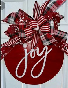 a christmas ornament hanging on a door with the word joy painted on it