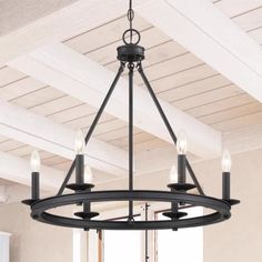 a chandelier hanging from the ceiling in a room with white walls and beams