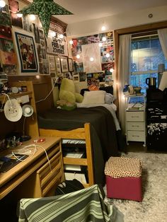 a dorm room filled with lots of clutter and pictures on the wall above it