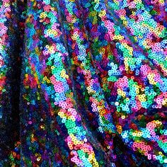 an image of colorful sequins in the middle of a quilted material pattern