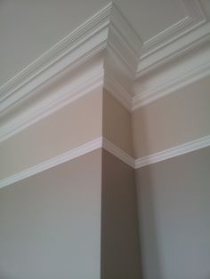 the corner of an empty room with white trim on the walls and ceiling above it