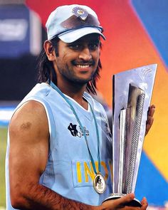 a man with long hair holding a trophy