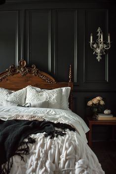 a bedroom with black walls and white bedding, chandelier in the corner