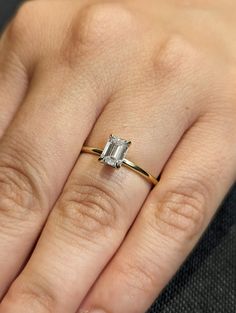 a woman's hand with a diamond ring on top of her finger and an engagement band