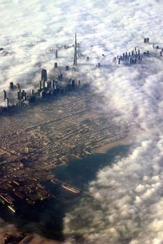 an aerial view of the city in the clouds