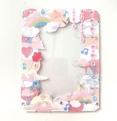 a pink and white photo frame with clouds, rainbows and hearts on the front