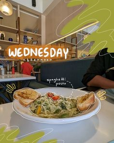 a white plate topped with food on top of a table next to a person sitting at a table