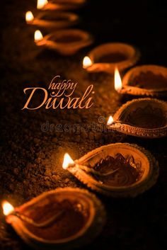 happy diwali with lit candles on the ground