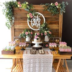 the dessert table is decorated with flowers and greenery