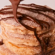 chocolate drizzled on top of a stack of pancakes