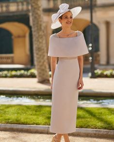 a woman wearing a white hat and dress