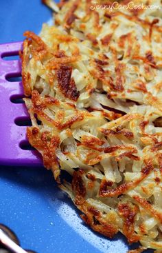 a close up of food on a plate with a purple spatula next to it