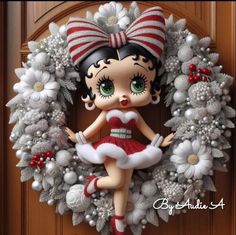 a christmas wreath with a doll sitting on it's front door and flowers around the wreath