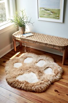 an animal print rug is on the floor in front of a bench and table with a potted plant