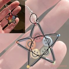 a hand holding a small star shaped object with buttons on it's fingers and an image of a person wearing a ring