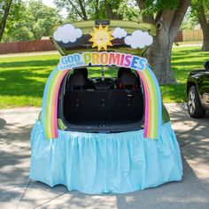 the trunk of a car decorated to look like a rainbow with clouds and sun on top