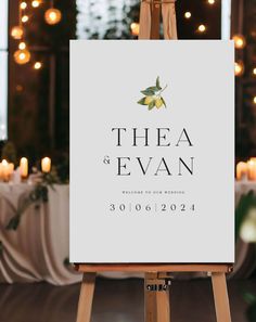 an easel with a sign that says thea and evan on it in front of candles