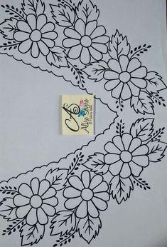 a white table cloth with black flowers on it and a sticker in the middle