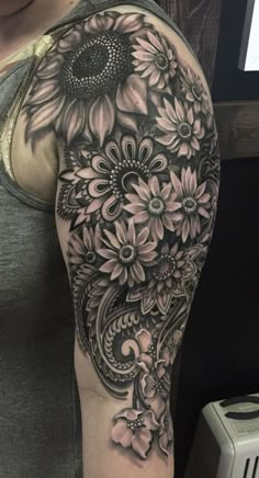 a woman's arm with sunflowers and flowers on it