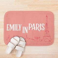 a pair of white slippers sitting on top of a pink rug with the words family in paris