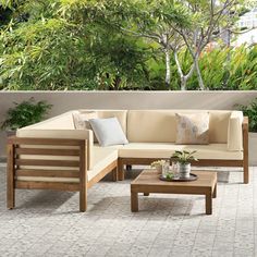 a couch and table on a patio with trees in the background