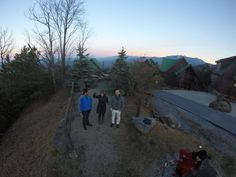 three people walking up a hill at dusk