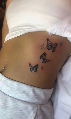 a woman's stomach with three butterflies on the side and stars in the middle