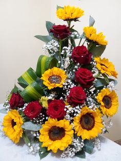 a bouquet of sunflowers and roses on a table