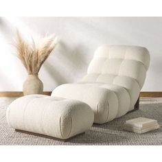 a white reclining chair sitting on top of a rug next to a tall plant