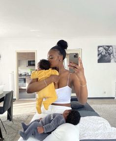 a woman taking a selfie with her baby while sitting on a bed in the living room