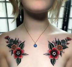 a woman's chest with flowers on it and a blue diamond in the center