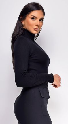 Turtleneck top Slim fit Light weight Gold bottom accents 52% Viscose, 30% Polyester, 18% Nylon Model's height: 5'6" Model is wearing size S Sleek Black Turtleneck Top, Sleek Stretch Winter Tops, Black High Neck Top For Work, Sleek High Stretch Winter Tops, Winter High Neck Black Tops, Sleek Winter Tops, High Stretch Black Tops For Work, Black High Stretch Tops For Workwear, Black High Stretch Top For Work