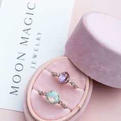 two rings sitting in a pink velvet box