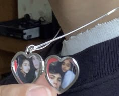 a person holding two heart shaped pendants in their left hand and the other one has an image on it