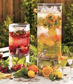 two large vases filled with different types of fruit and veggies on a table