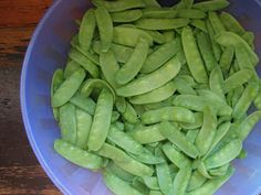 green beans in a blue bowl on a wooden table