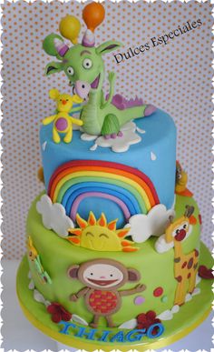 a birthday cake decorated with animals and rainbows