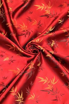 a red fabric with yellow leaves on it