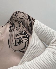 the back of a woman's neck with black and white swirls on it