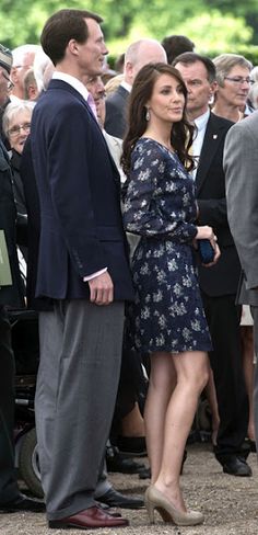 a man and woman standing next to each other in front of a group of people